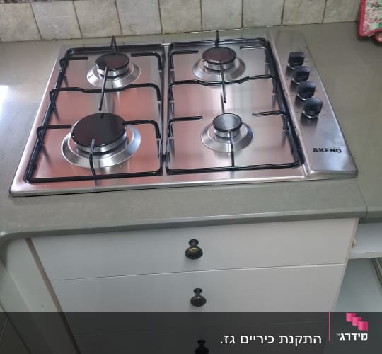כיריים גז במטבח עם כפתורים בצד ימין